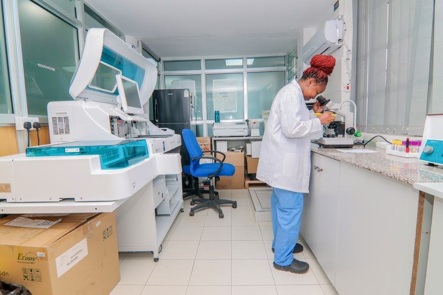 Laboratory technician examining a sample under a microscope