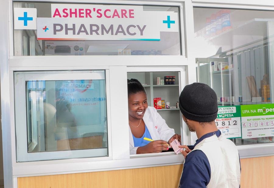 Pharmacist serving a customer at Asher's Care Pharmacy